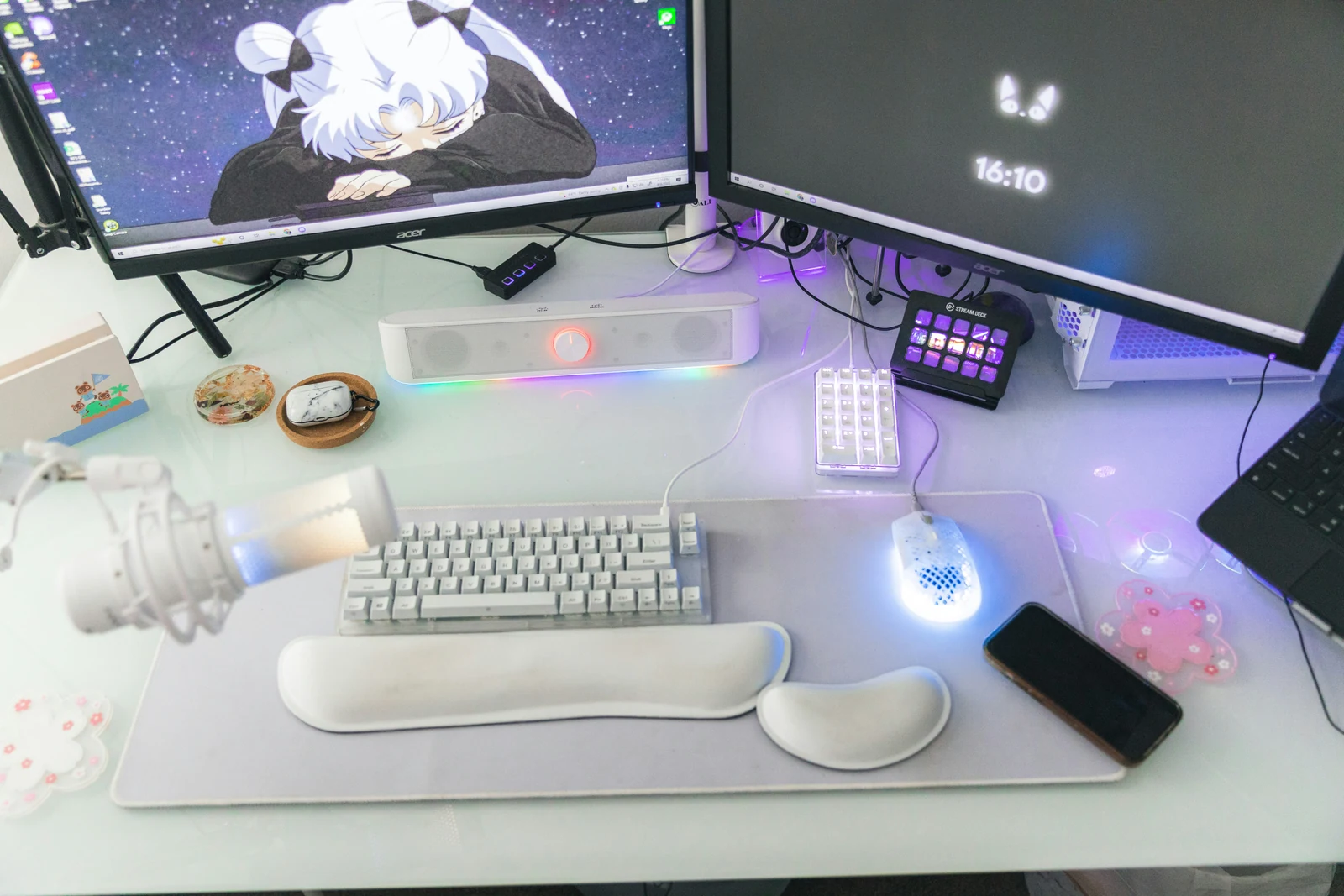 Bright streaming desk with dual monitors, a microphone, keyboard and stream controller